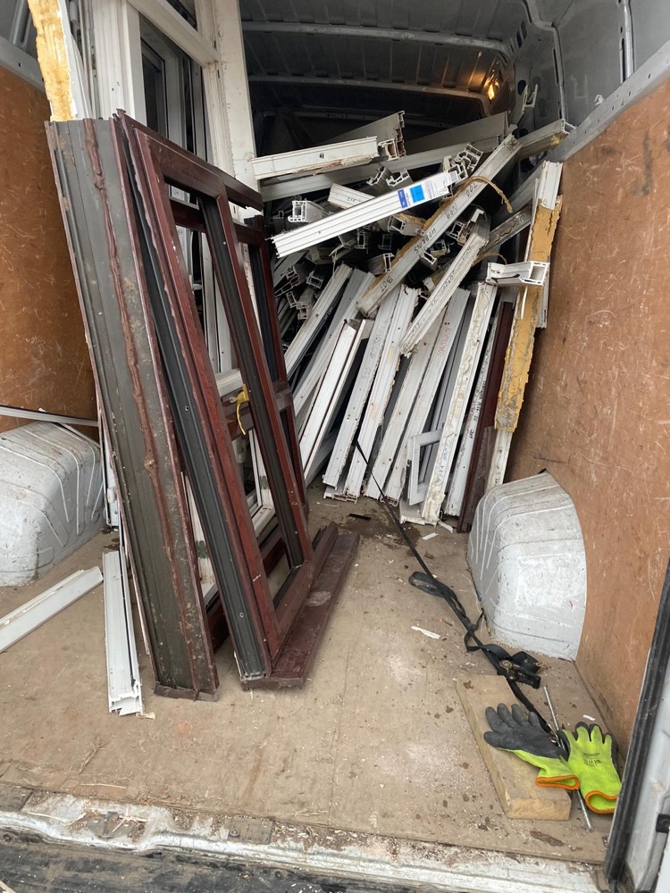 Mixed-colour uPVC frames inside a collection van after a job