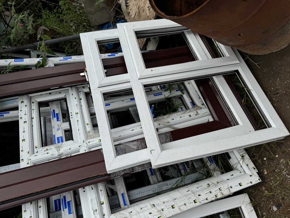 Stacked uPVC frames with manufacturer labels at our recycling yard