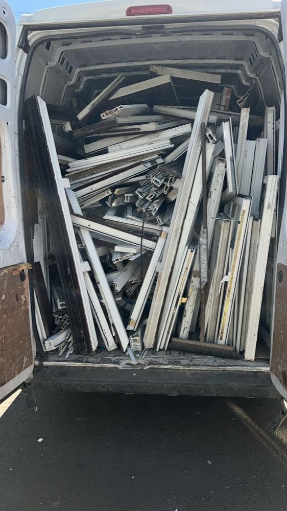 Collection van loaded with uPVC profile offcuts from a fabricator's saw cell