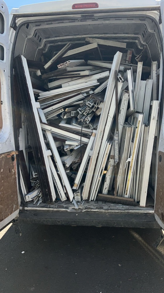 Collection van loaded with uPVC profile offcuts from a fabricator's saw cell